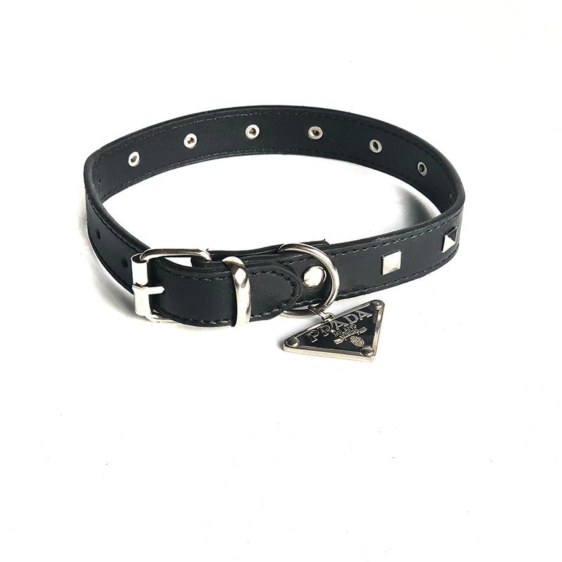 Collare per cani con borchie quadrate e placca metallica con logo triangolare.