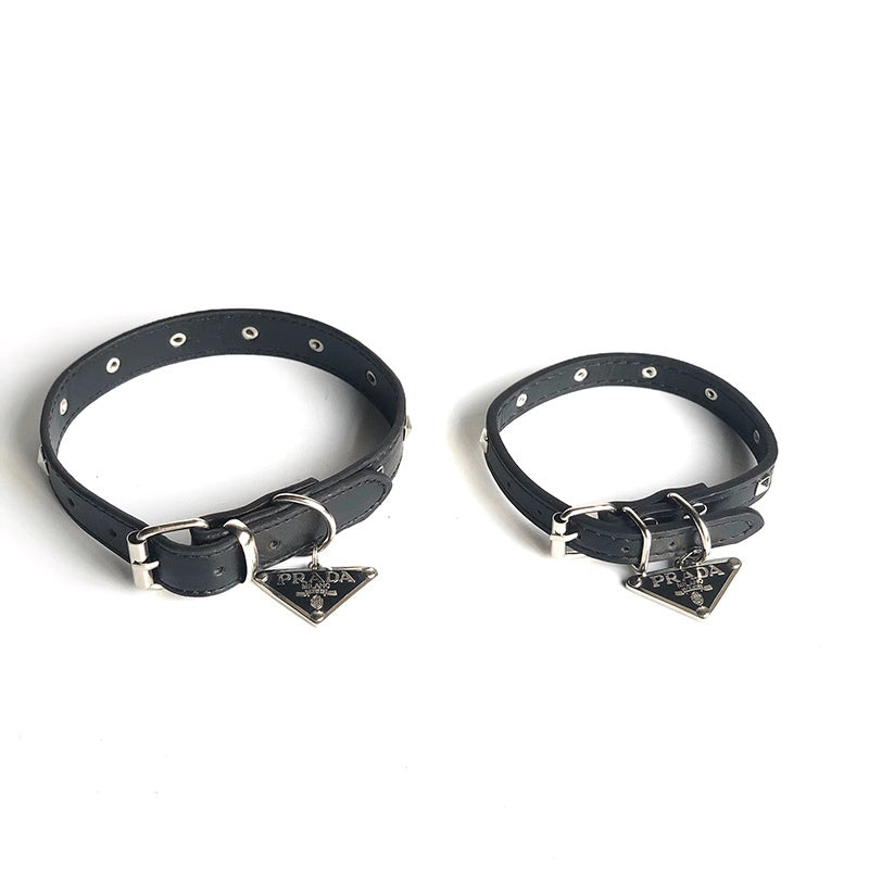 Collare per cani con borchie quadrate e placca metallica con logo triangolare.